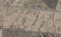 Photo aérienne de champs prise le printemps où on peut visualiser des zones plus humides et moins humides